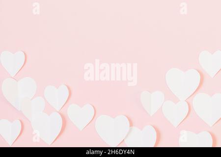 San Valentino sfondo con cuori bianchi su sfondo rosa pastello, spazio copia Foto Stock