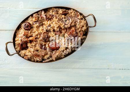 Risotto ai funghi, riso ai funghi, scattato dall'alto su un rustico sfondo di legno con un posto per il testo Foto Stock