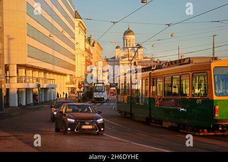 Due tram e traffico lento a Eteläranta, Helsinki, Finlandia, la mattina presto d'inverno. Cattedrale di Helsinki sullo sfondo. Novembre 2021. Foto Stock