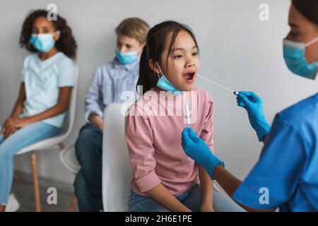 Ragazza premia giapponese che ottiene testato per Covid-19 in Clinic Indoor Foto Stock