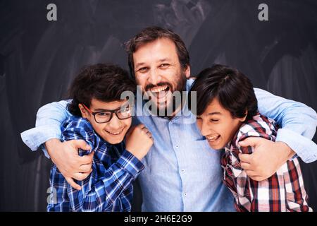 felice padre abbracciare figli momenti indimenticabili di gioia di famiglia in gara mista medio orientale famiglia araba Foto Stock