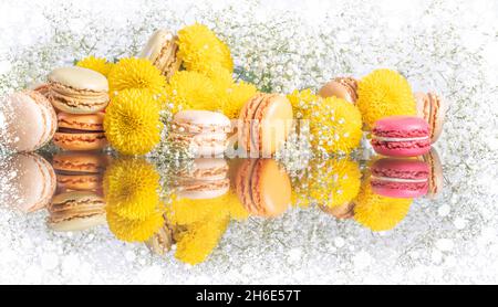 Macaroni colorati e bella composizione di fiori su sfondo Natale bianco. Foto di alta qualità Foto Stock