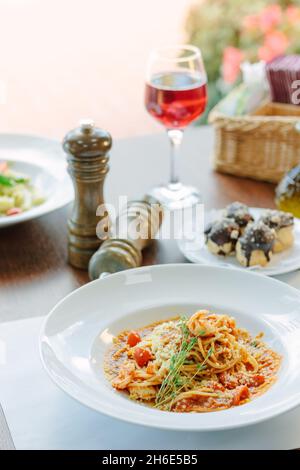 Spaghetti con pomodori e gamberi in un ristorante di cucina italiana Foto Stock