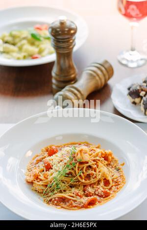 Spaghetti con pomodori e gamberi in un ristorante di cucina italiana Foto Stock