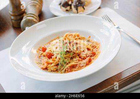 Spaghetti con pomodori e gamberi in un ristorante di cucina italiana Foto Stock