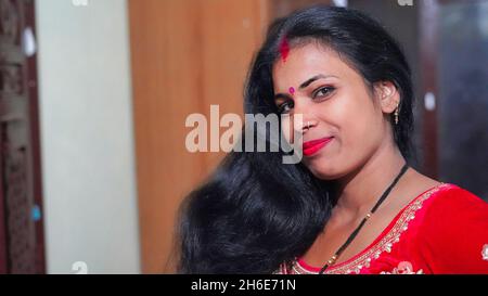 Giovane indiana con abito tradizionale. Testa ritratto girato di bella ragazza indiana sorridente giovane adulta attraente. Foto Stock