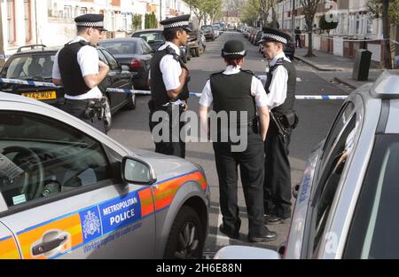 La famiglia e gli amici visitano la scena dove un ragazzo di 15 anni è morto di ferite da pugnale dopo un attacco di coltello per strada. I detective stanno cacciando i suoi attaccanti che hanno messo sopra l'adolescente a Edmonton, Londra del nord, la notte scorsa. Egli è il quarto adolescente a morire nella capitale quest'anno. Foto Stock