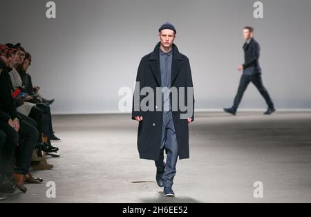 Un modello sulla pista alla sfilata Richard Nicoll al Mens London Fashion Week. Foto Stock