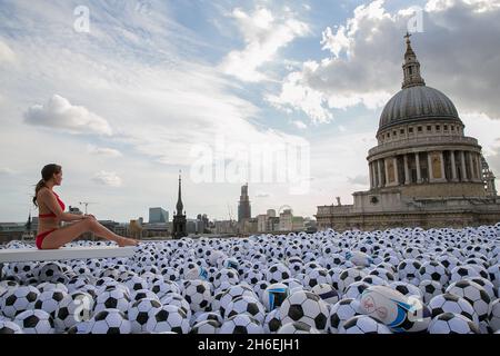 Virgin Media ha creato una piscina con 20,064 palline sportive sul tetto di One New Change di Londra per celebrare l'uscita dei suoi nuovi pacchetti sportivi. Foto Stock