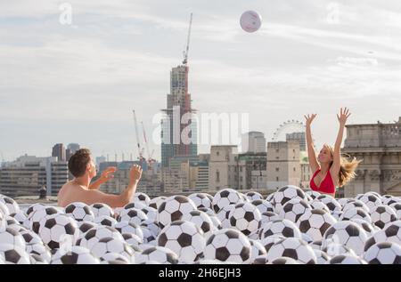 Virgin Media ha creato una piscina con 20,064 palline sportive sul tetto di One New Change di Londra per celebrare l'uscita dei suoi nuovi pacchetti sportivi. Foto Stock