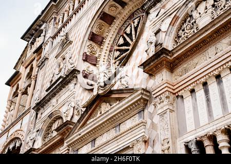 Statue, stampi intagliati, colonne e rosone sulla facciata della Cappella Colleoni. Bergamo, Italia Foto Stock