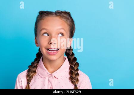 Foto di giovane ragazza allegra sorriso felice positivo guardare spazio vuoto curioso isolato su sfondo di colore blu Foto Stock