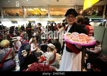 Al Terminal 1 di Heathrow si è svolta una protesta contro la corsa al clima contro una terza pista all'aeroporto. Centinaia di manifestanti sono arrivati in abito edoardiano con cialde di cibo per avere un 'Dinner alle Partenze nazionali'. Foto Stock