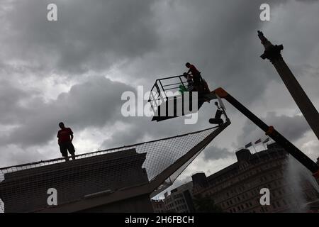 Jill Gatchum prende il controllo da Jason Clark. Il londoner Jill Gatchum ha pubblicato 60 palloncini per beneficenza sulla plinth a Trafalgar Square questa mattina. L'una e l'altra scultura di Antony Gormley coinvolge una persona diversa che è sulla base per un'ora ciascuno, 24 ore al giorno per 100 giorni tra il 6 luglio e il 14 ottobre. Foto Stock