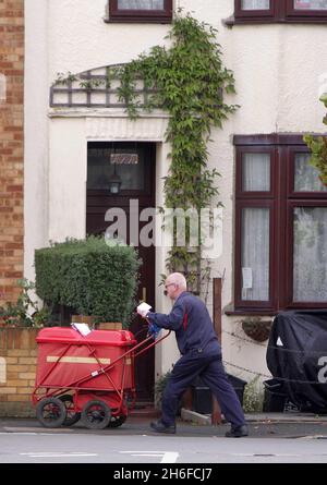 Un postman Royal Mail consegna lettere a East London questa mattina il personale dell'ufficio smistamento sta organizzando uno sciopero di 24 ore oggi seguito da uno sciopero di 24 ore dal personale di consegna domani Foto Stock