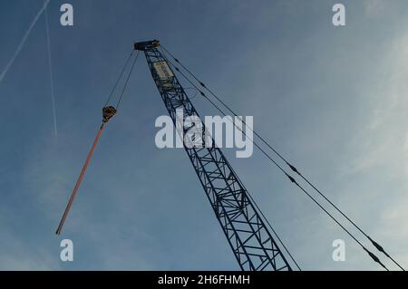 FRANCOFORTE, GERMANIA - 29 ottobre 2021: Il boom di una gru contro un cielo blu su un cantiere sulle pareti del molo del fiume meno a Francoforte. SIL Foto Stock