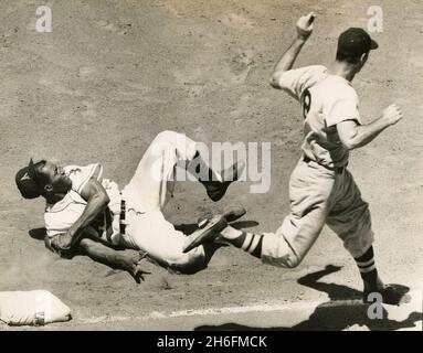 Il primo baseman americano Vic Power del baseball rotola sopra per taggare il sacchetto in tempo per ottenere il catcher del Red Sox Pete Daley (8) per l'uscita, Boston, USA 1956 Foto Stock