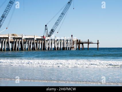 Foto del molo della spiaggia di Jacksonville guardando da sud verso nord. Il molo è in fase di riparazione dopo essere stato danneggiato durante un uragano. Foto Stock