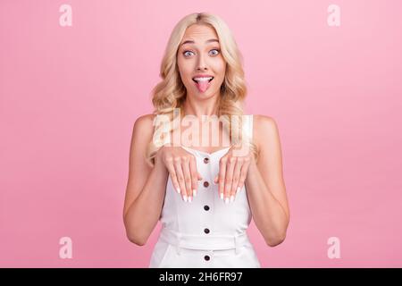 Foto di brillante divertente giovane donna vestita bianco generale sorridente mostrando lingua cane isolato colore rosa sfondo Foto Stock