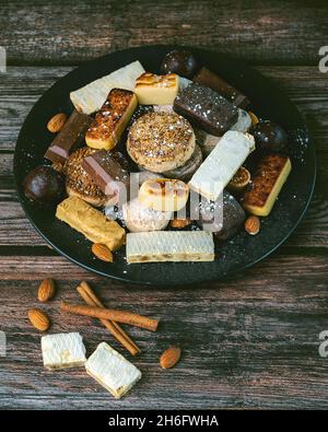 Torrone dolce di natale, mantecados e polvoroni su tavola di legno. Assortimento di dolci di natale tipici della Spagna Foto Stock