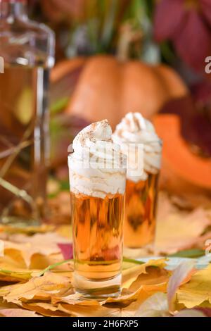 Due vodka con torta di zucca crema alla cannella spara in bicchieri da shot. Queste bevande sono facili da preparare e perfette per l'autunno. Prova queste bevande boozy al tuo Foto Stock