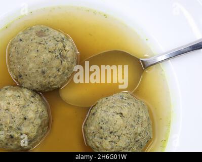 boulion con gnocchi di fegato e cucchiaio in piatto bianco per zuppa, vista dall'alto Foto Stock