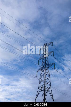 I piloni elettrici attraversano la campagna del Pennine vicino Halifax, Calderdale, West Yorkshire. Una torre di trasmissione, nota anche come pilone elettrico o semplicemente come pilone inglese britannico e come idro torre in inglese canadese, è una struttura alta, solitamente una torre reticolare in acciaio, utilizzata per sostenere una linea elettrica aerea. Nelle reti elettriche, esse sono generalmente utilizzate per trasportare linee di trasmissione ad alta tensione che trasportano energia elettrica di massa dalle stazioni di generazione alle sottostazioni elettriche. Foto Stock