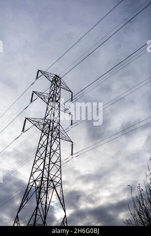 I piloni elettrici attraversano la campagna del Pennine vicino Halifax, Calderdale, West Yorkshire. Una torre di trasmissione, nota anche come pilone elettrico o semplicemente come pilone inglese britannico e come idro torre in inglese canadese, è una struttura alta, solitamente una torre reticolare in acciaio, utilizzata per sostenere una linea elettrica aerea. Nelle reti elettriche, esse sono generalmente utilizzate per trasportare linee di trasmissione ad alta tensione che trasportano energia elettrica di massa dalle stazioni di generazione alle sottostazioni elettriche. Foto Stock