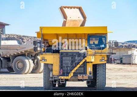 Camion e macchinari minerari a Corta Atalaya miniera aperta buca. Scavi profondi di pirite ed estrazione di minerali di cooper e oro in comune di Foto Stock