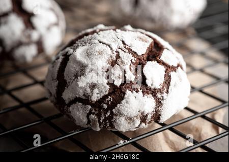 Deliziatevi con biscotti al cioccolato fatti in casa con grata glassa di zucchero a velo per rinfrescarvi su sfondo di pietra scura. Primo piano Foto Stock