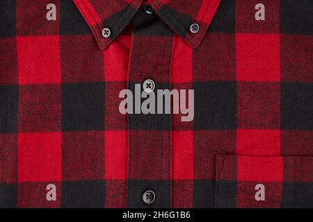 Fotografia dettagliata di una camicia in flanella da uomo con motivo tartan, che mostra una parte del colletto e della tasca con la linea centrale e i bottoni Foto Stock