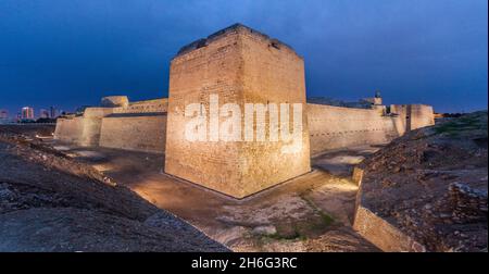 Vista serale del Forte Qal al-Bahrain illuminato nel Bahrain Foto Stock