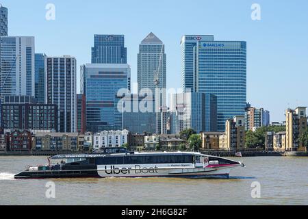 Clipper del Tamigi, Uber Boat sul Tamigi con grattacieli di Canary Wharf sullo sfondo, Londra Inghilterra Regno Unito Foto Stock