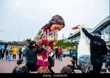 Una cicogna di marionette è visto interagire con Little Amal.amare, un nuovo centro culturale nel centro dell'Aia ha organizzato come parte del suo 'Open Festival', la visita del gigante burattino 'Little Amal', una bambina siriana di nove anni rifugiati e oltre 11 piedi di altezza al parco in miniatura, Madurodam. È invitata a partecipare al Festival come ospite speciale della città per attirare l'attenzione in tutta Europa sulla situazione dei giovani rifugiati fuggiti dalla Siria. Amal è stata ricevuta fuori dal parco da un gruppo di bambini, dopo di che poteva camminare intorno alle repliche in scala 1:25 del famoso landmar olandese Foto Stock