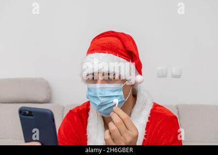 Vestito come Babbo Natale che parla tramite videoconferenza Foto Stock