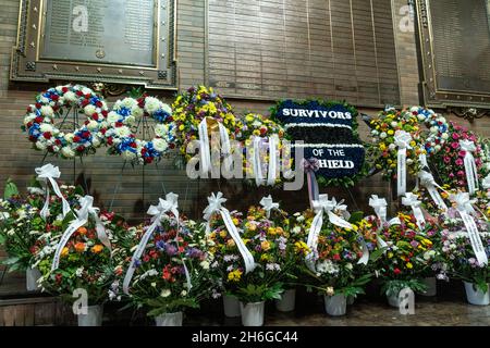 New York, NY - 15 novembre 2021: Fiori di diverse organizzazioni NYPD visti al Memorial Wall durante la cerimonia commemorativa in una piazza della polizia Foto Stock