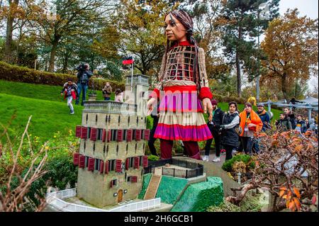 Little Amal è visto a piedi intorno agli edifici della miniatura. Amare, un nuovo centro culturale nel centro dell'Aia ha organizzato come parte del suo 'Open Festival', la visita del marioncino gigante 'Little Amal', una bambina siriana di nove anni rifugiati e oltre 11 piedi di altezza al parco in miniatura, Madurodam. È invitata a partecipare al Festival come ospite speciale della città per attirare l'attenzione in tutta Europa sulla situazione dei giovani rifugiati fuggiti dalla Siria. Amal è stata ricevuta fuori dal parco da un gruppo di bambini, dopo di che poteva camminare intorno alle repliche in scala 1:25 del famoso olandese Foto Stock