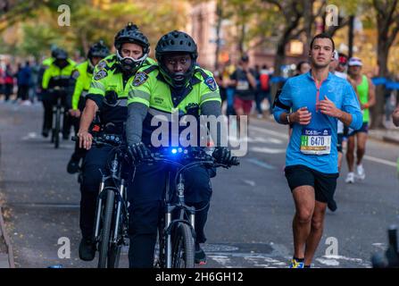 Una falanga di ufficiali NYPD in bicicletta a Harlem a New York vicino al 22 miglia marchio vicino a Mount Morris Park la Domenica, 7 novembre 2019 nella 50 ° corsa della maratona TCS New York City. Circa 30,000 corridori. Giù dal solito 50,000, hanno partecipato alla gara che è stata cancellata l'anno scorso a causa della pandemia. (© Richard B. Levine) Foto Stock