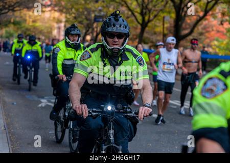 Una falanga di ufficiali NYPD in bicicletta a Harlem a New York vicino al 22 miglia marchio vicino a Mount Morris Park la Domenica, 7 novembre 2019 nella 50 ° corsa della maratona TCS New York City. Circa 30,000 corridori. Giù dal solito 50,000, hanno partecipato alla gara che è stata cancellata l'anno scorso a causa della pandemia. (© Richard B. Levine) Foto Stock