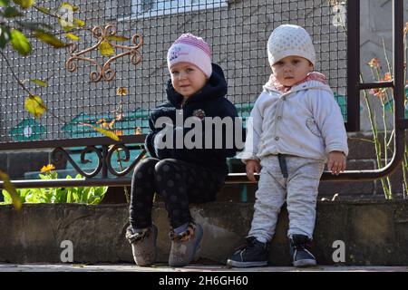 Verkhnotoretske, Donetsk, Ucraina. 16 ottobre 2021. I bambini sono visti seduti accanto alla casa nella periferia di Verkhnotoretske Village.Verkhnotoretske è un insediamento ucraino di tipo urbano situato sulla prima linea nel distretto di Yasynuvata in Donetsk oblast dell'Ucraina orientale. Durante la guerra di Donbas, iniziata a metà aprile 2014, la linea di separazione tra le parti in guerra è stata situata nelle vicinanze dell'insediamento. Il villaggio era una zona grigia fino alla fine del 2017. Oggi Verkhnotoretske è un territorio ucraino. Il conflitto ha portato avanti il cas civile e militare Foto Stock