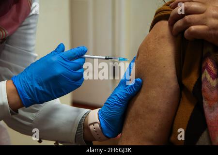 Londra, Regno Unito. 15 Nov 2021. Un vaccinatore NHS, somministra il vaccino di richiamo Pfizer/BioNTech Covid-19 ad una donna in un centro di vaccinazione. (Credit Image: © Dinendra Haria/SOPA Images via ZUMA Press Wire) Foto Stock