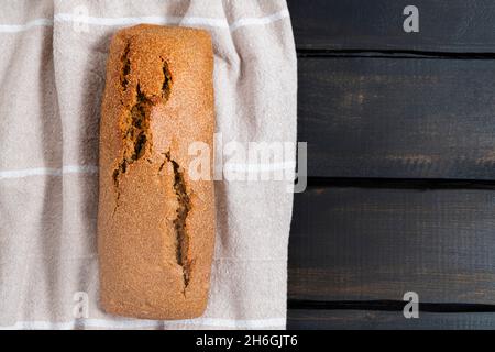 Vista dall'alto del pane casereccio su sfondo di legno scuro, spazio copia Foto Stock