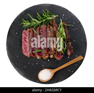 pezzo fritto di ribeye di manzo tagliato a pezzi su una tavola nera, raro grado di donezza. Deliziosa bistecca, vista dall'alto Foto Stock