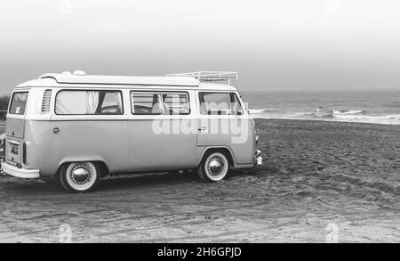 Volkswagen VW tipo 2 Transporter Caravette camper RV con tetto apribile sulla spiaggia sulla costa del Mare del Nord, Lincolnshire, Regno Unito in bianco e nero Foto Stock