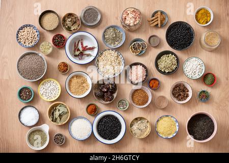 Set di grandi quantità di ciotole piene di legumi e condimenti per cucinare deliziose ricette della cucina mediterranea con riso, fagioli, sale, lenticchie, pepe Foto Stock