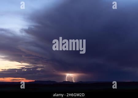 Tempesta di tuoni in lontananza con fulmini sull'Arches National Park, Utah Foto Stock