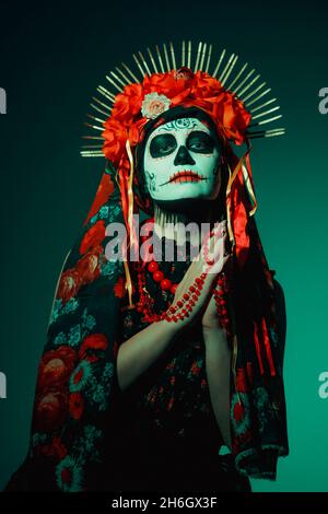 Giovane donna in stile calavera con teschio messicano sul viso Foto Stock