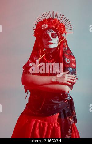 Giovane donna in stile calavera con teschio messicano sul viso Foto Stock