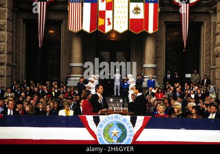 Austin Texas USA, gennaio 1995: George W. Bush, con la moglie Laura Bush al suo fianco, presta giuramento come governatore del Texas durante la cerimonia di inaugurazione al Campidoglio del Texas. Bush sconfisse l'operatore storico, Gov. Ann Richards, nella corsa del governatore del novembre 1994. ©Bob Daemmrich Foto Stock