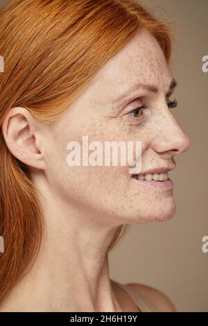 Profilo verticale ritratto di bella donna con capelli rossi con frickles sorridente Foto Stock